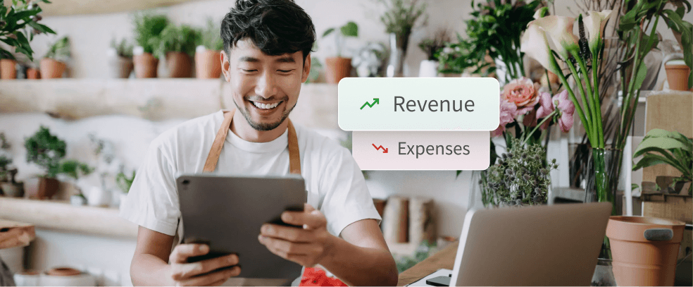 Florist managing shop finances on a tablet with revenue growth and expense reduction overlays.